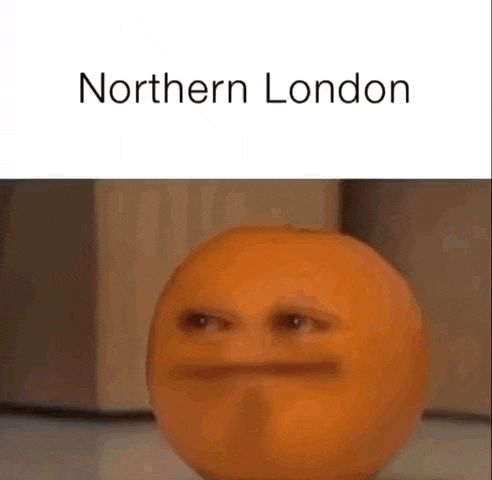 a red apple with a face on it is sitting on a counter next to a refrigerator .