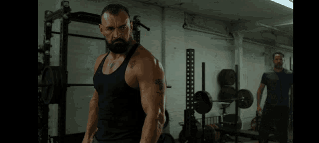 a man in a tank top has a tattoo on his arm that says ' a ' on it
