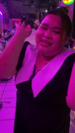 a person with a purple background is making a face