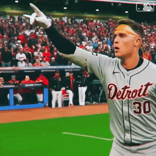 a baseball player wearing a detroit jersey is standing on the field