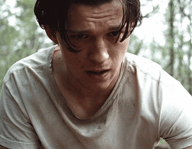 a close up of a man 's face in a white t-shirt