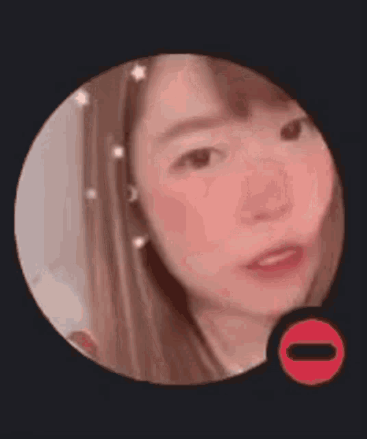 a close up of a woman 's face in a circle with a red circle .