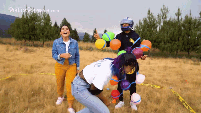 a group of people are playing with water balloons in a field with the website plasticapolynesia.com