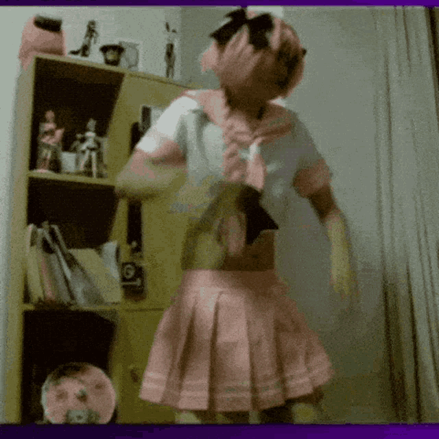 a person in a pink and white costume is dancing in a room .