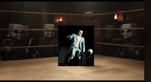 a man in a suit is standing in a boxing ring with a ball