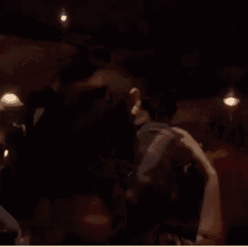 a man and woman kissing in a dark room .