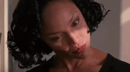 a close up of a woman with curly hair and red lipstick .