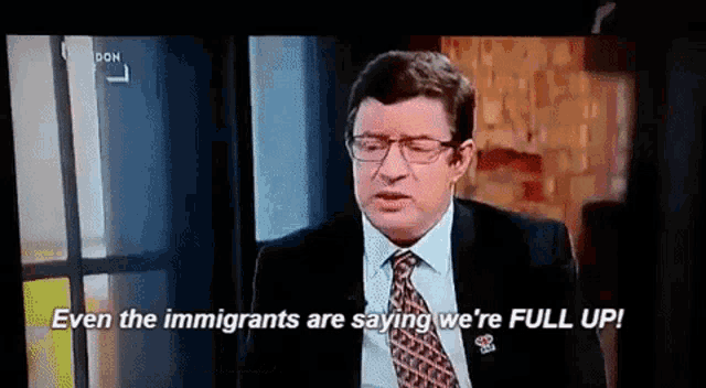 a man in a suit and tie says even the immigrants are saying we are full up