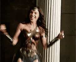 a woman in a wonder woman costume is standing next to a pillar .