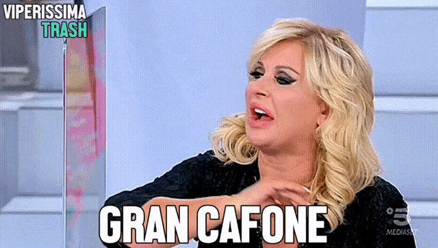 a woman says gran cafone while sitting in front of a sign that says viperissima trash