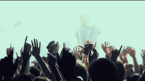 a man is singing into a microphone while a crowd watches