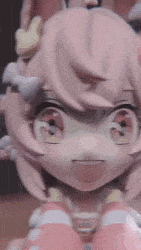 a close up of a doll with pink hair and a bunny ears .