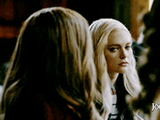 two women are standing next to each other and one of them is blonde .