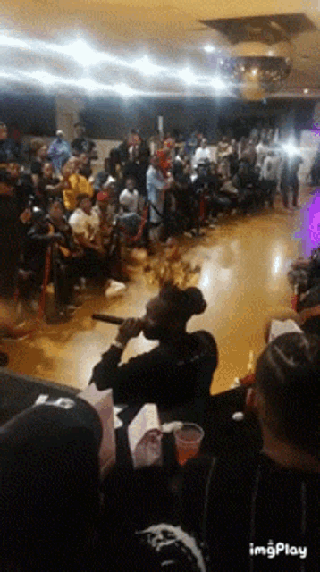 a group of people are gathered in a room with the word imgplay on the bottom right