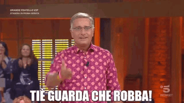 a man wearing a pink shirt with the words tie guarda che robba on it
