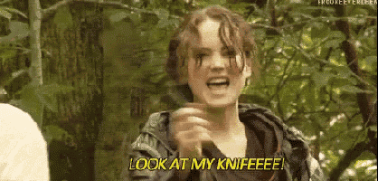 a woman is standing in the woods holding a knife and saying `` look at my knife ! ''