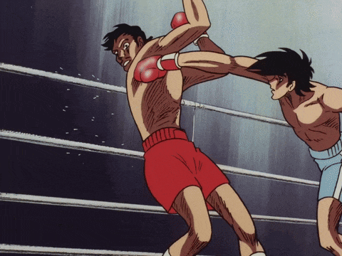 two boxers are fighting in a ring and one is wearing red gloves