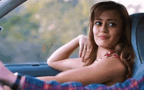 a woman is sitting in the back seat of a car with a man .