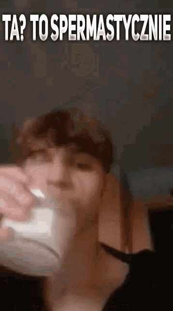 a man is drinking from a cup with the words `` ta ? to spermatycznie '' written on the bottom .