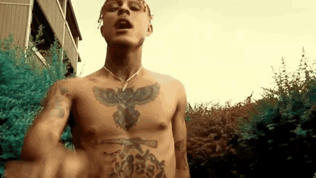 a man without a shirt has a tattoo on his chest .