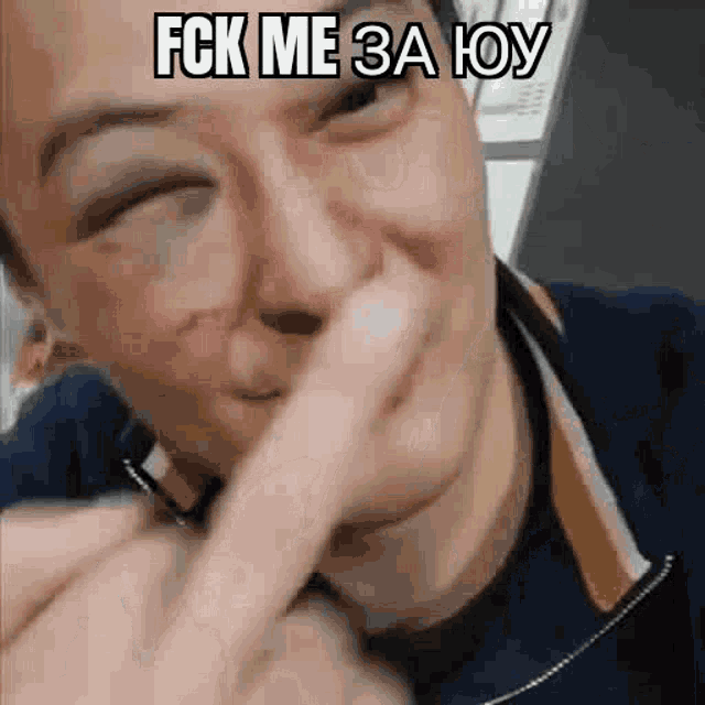 a close up of a person covering their nose with their finger and making a funny face .