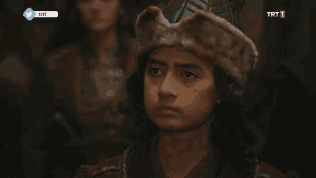a young boy wearing a fur hat with trt1 on the bottom of the screen