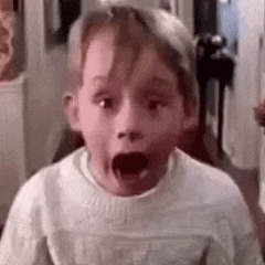 a young boy with his mouth open is making a surprised face .