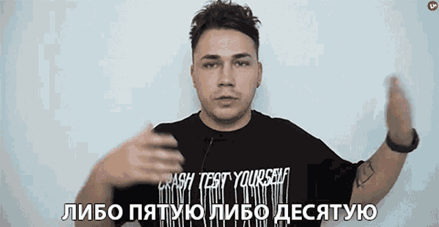 a man wearing a black shirt that says crash test yourself on it