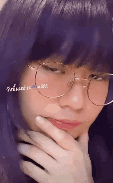 a woman wearing glasses and purple hair has a purple arrow pointing to the right