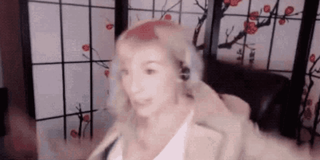 a woman wearing headphones is standing in front of a sliding glass door .