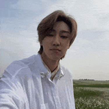 a young man in a white shirt is taking a selfie