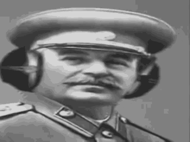 a black and white photo of a man in a military uniform wearing headphones .