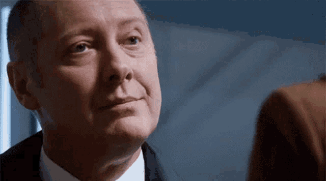 a man in a suit and tie is looking at another man in a suit and tie .
