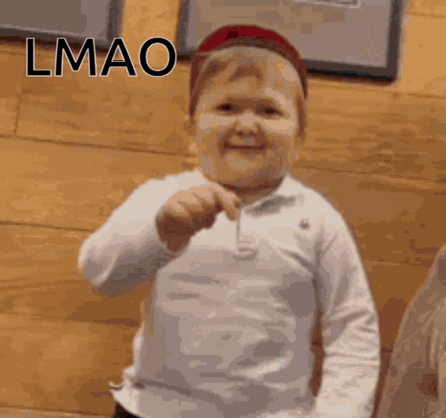 a little boy wearing a red hat and a white shirt with the word lmao written on it