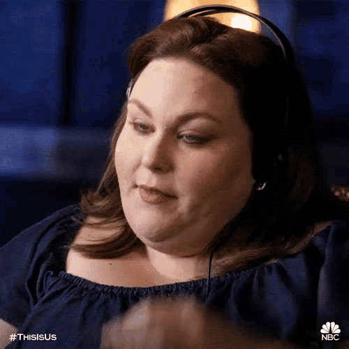 a woman wearing headphones is sitting in a chair and making a funny face .