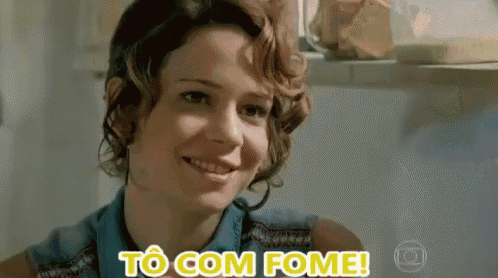 a woman with curly hair is smiling and says to com fome .