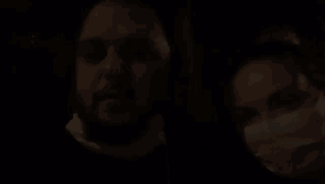 a man and a woman wearing face masks in a dark room .