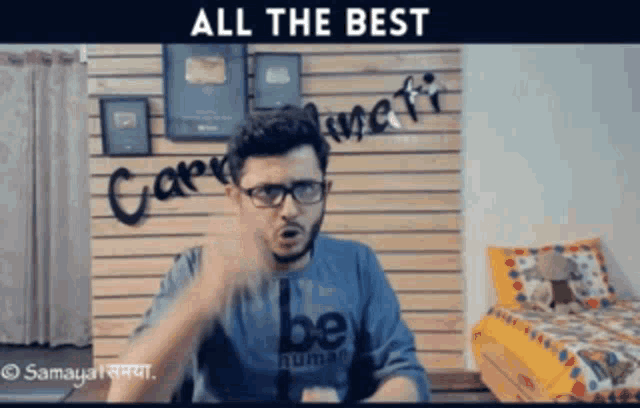 a man wearing glasses and a shirt that says " be human "