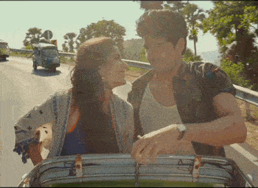 a man and woman are looking into each other 's eyes while sitting in the back of a car