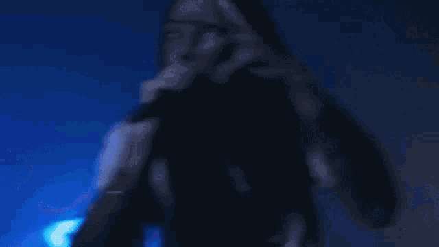 a person is singing into a microphone in a dark room