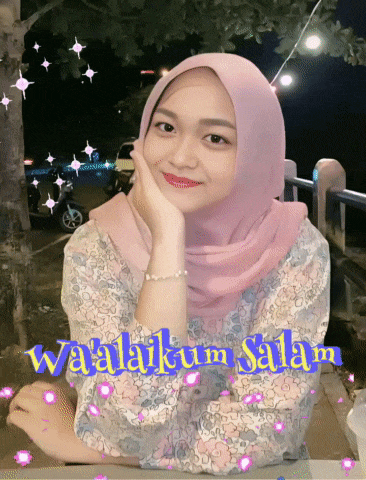 a woman wearing a pink hijab is sitting at a table with the words waalaikum salam below her