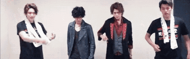 a group of young men are standing next to each other and dancing .
