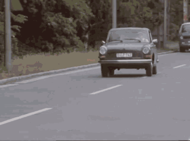 a man is driving a green car with a license plate that says gnlp792