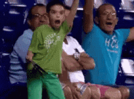 a group of people are sitting in a stadium with one wearing a shirt that says hco