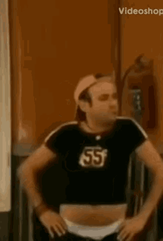 a man in a black shirt with the number 55 on it is dancing .