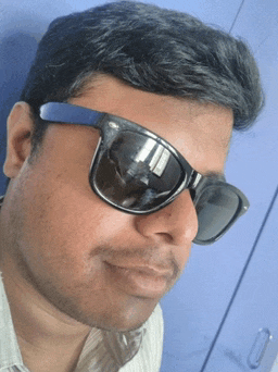 a close up of a man wearing sunglasses against a blue wall