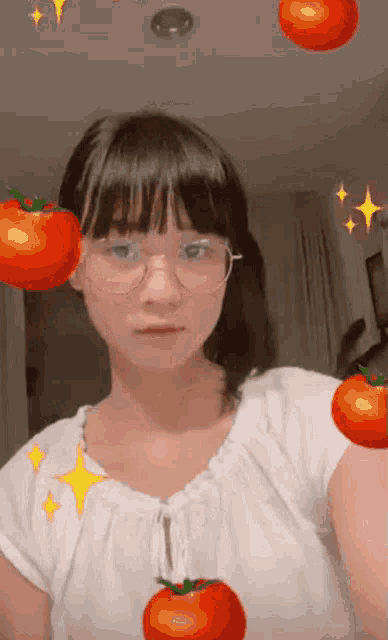 a girl wearing glasses is surrounded by tomatoes and stars .