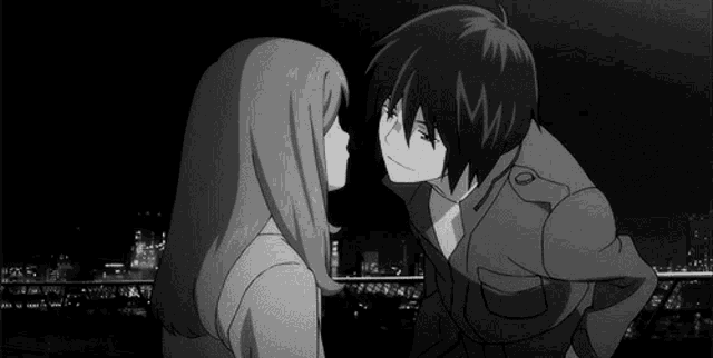 a boy and a girl are kissing each other in a black and white photo .