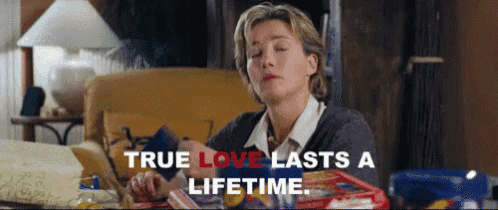 a woman is sitting at a table with her eyes closed and the words `` true love lasts a lifetime '' written above her .