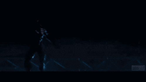 a man in a black suit is hanging from the ceiling